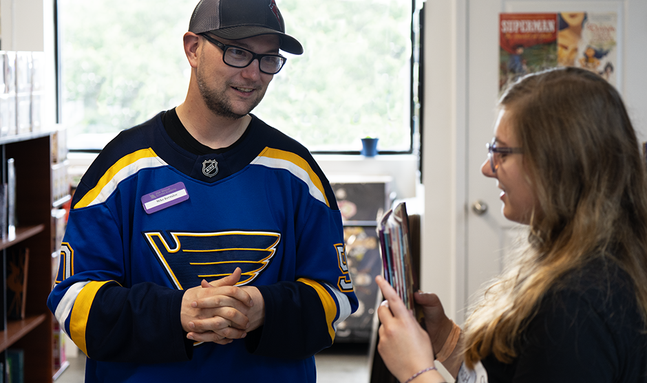 Mike Kersulov talking to one of his students during a visit to a local comic shop.