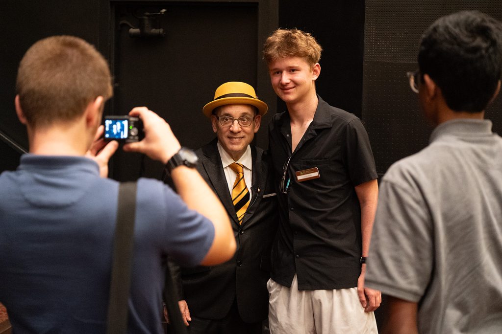 Cal Fussman smiling while posing for a picture with a student.